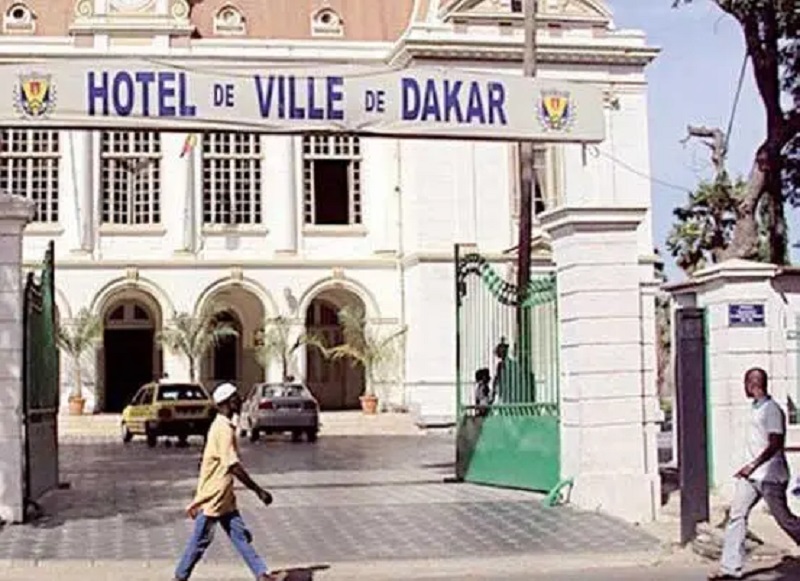 Image de Politique. Sous la présidence de Barthélemy Dias, la Mairie de Dakar renouvelle son bureau municipal en respectant la parité, conformément à une décision de la Cour d'appel. Ngoné Mbengue, anciennement deuxième adjointe, devient la première adjointe, remplaçant Abass Fall. Le Conseil municipal a adopté la loi de la parité pour cette réorganisation. Comment la redéfinition des rôles au sein de l'administration municipale pourrait-elle influencer la dynamique politique et la gouvernance locale ?