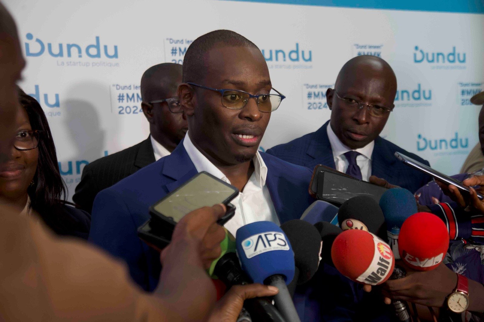 Deuxième Image de Politique. Le 7 octobre 2023, à Dakar, la Coalition Dundu a été officiellement lancée, une "startup politique" dirigée par des technocrates et des chefs d'entreprises sénégalais. La cérémonie a présenté les origines de Dundu, sa vision politique, et son candidat Mouhamadou Madana Kane, âgé de 41 ans. Mais est-ce ? Madana, ancien DG de la Banque Islamique du Sénégal, est un juriste et banquier formé au Sénégal, en France, en Angleterre et aux États-Unis. Il est également fondateur de l'African Center of International Law Practice et membre du Groupe des Pairs de la Columbia Center of Sustainable Investment. La création de Dundu découle de la volonté de technocrates de s'engager en politique pour révolutionner la scène politique sénégalaise. Ils souhaitent mettre l'homme sénégalais au cœur de l'action publique avec une vision axée sur l'innovation, l'agilité, les résultats et la disruption. Malgré des contraintes liées au parrainage, Dundu prépare sa participation électorale depuis plusieurs mois avec la création de cellules de militants à travers le pays. Que savez-vous de Mouhamadou Madana Kane?